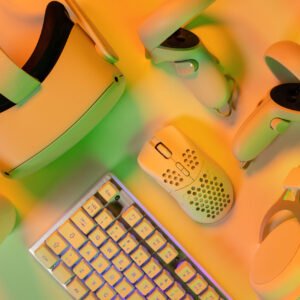 Overhead view of keyboard modern accessories on orange professional gaming desk